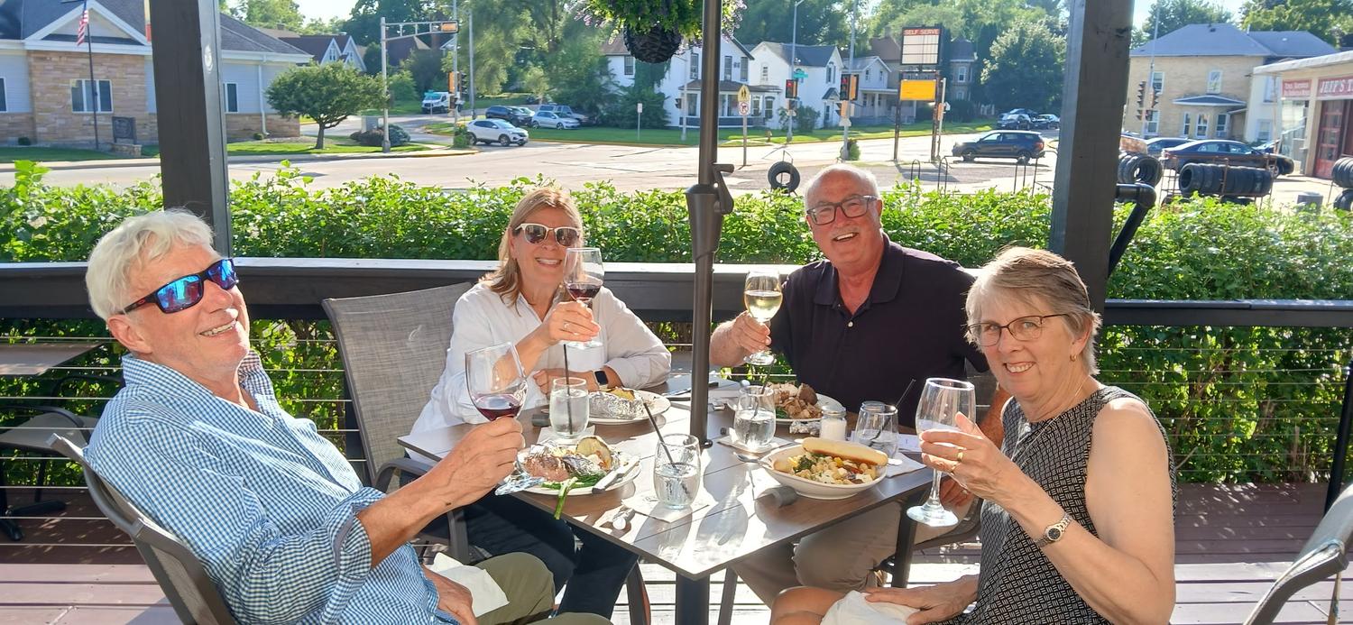 Guests raising a glass on the patio at Neil's Winehouse
